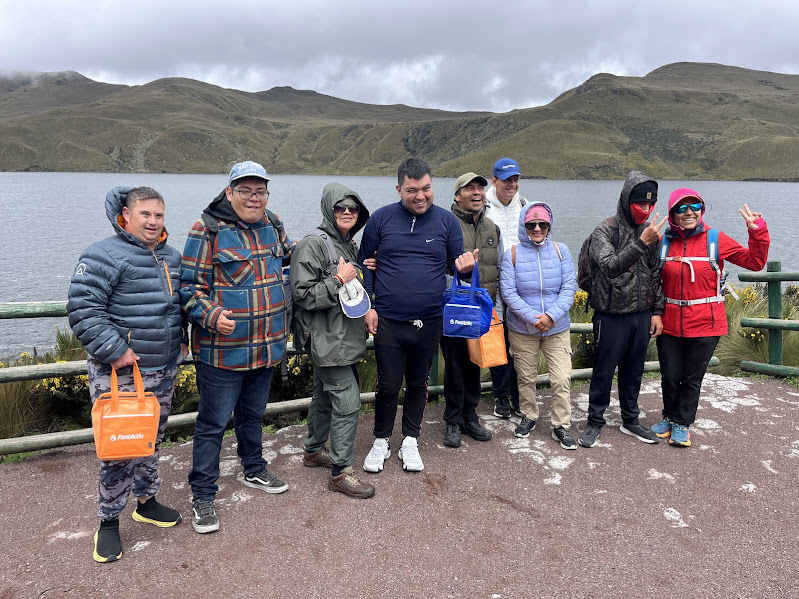 FINESEC participants and volunteers posing together in front of an Andean lake