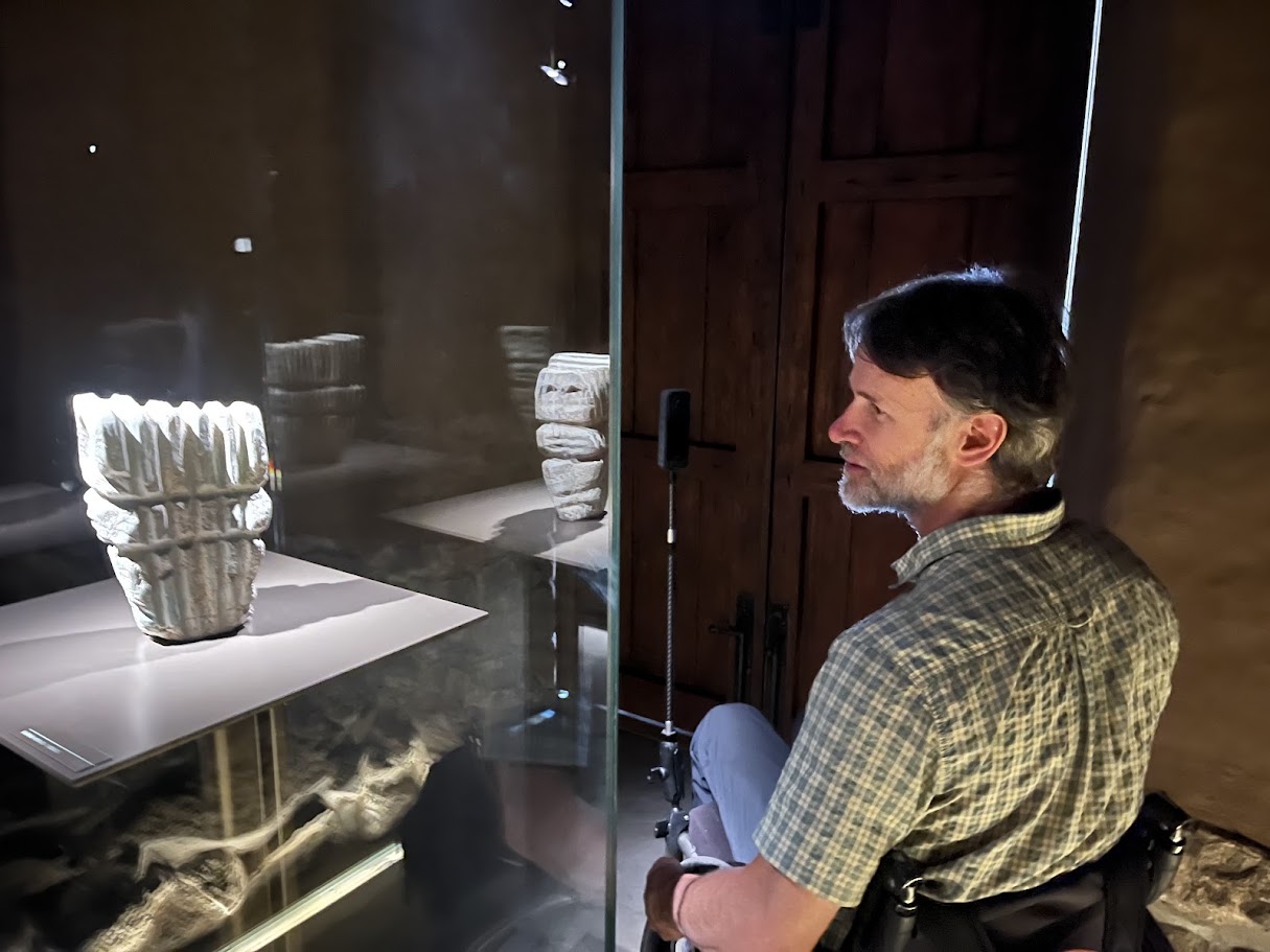 Zuko Carrasco looking at an archaeological piece inside a museum